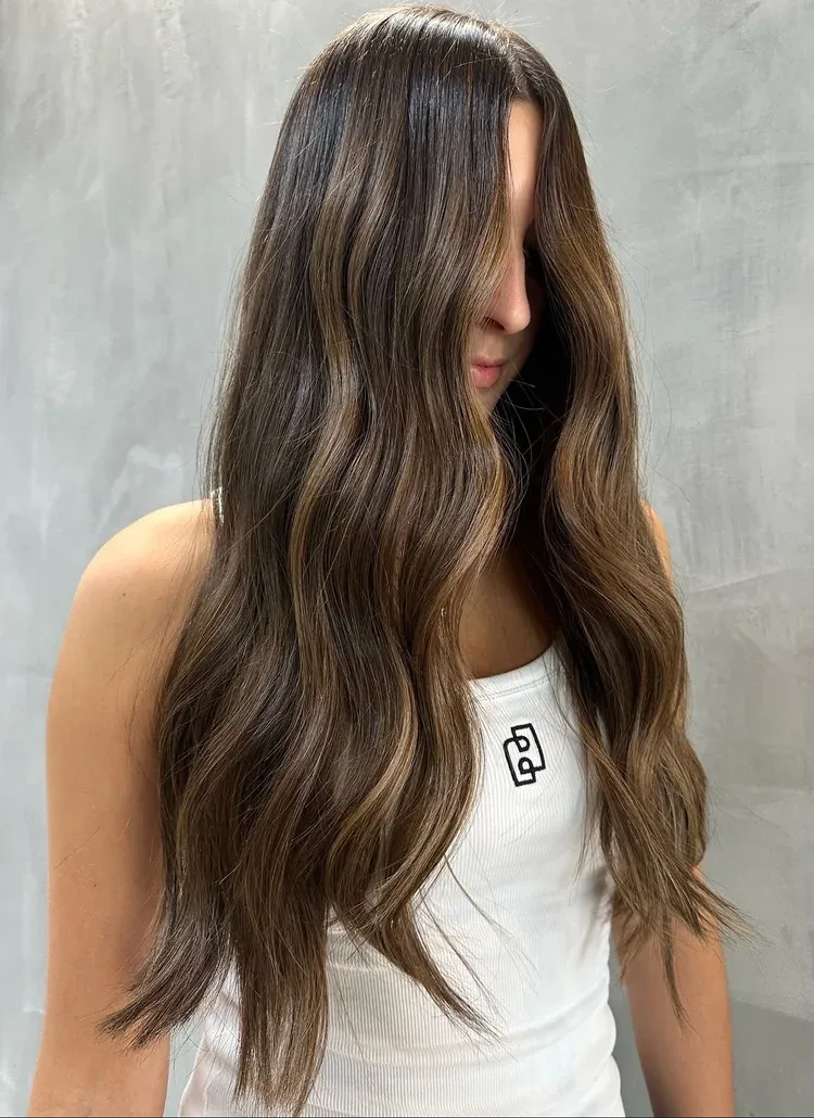 Long glossy brunette waves with soft dimensional colour