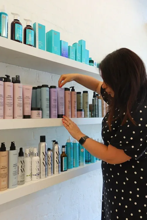 Client browsing the Liberty and Frank retail product wall — Moroccanoil and Kevin Murphy on the shelves